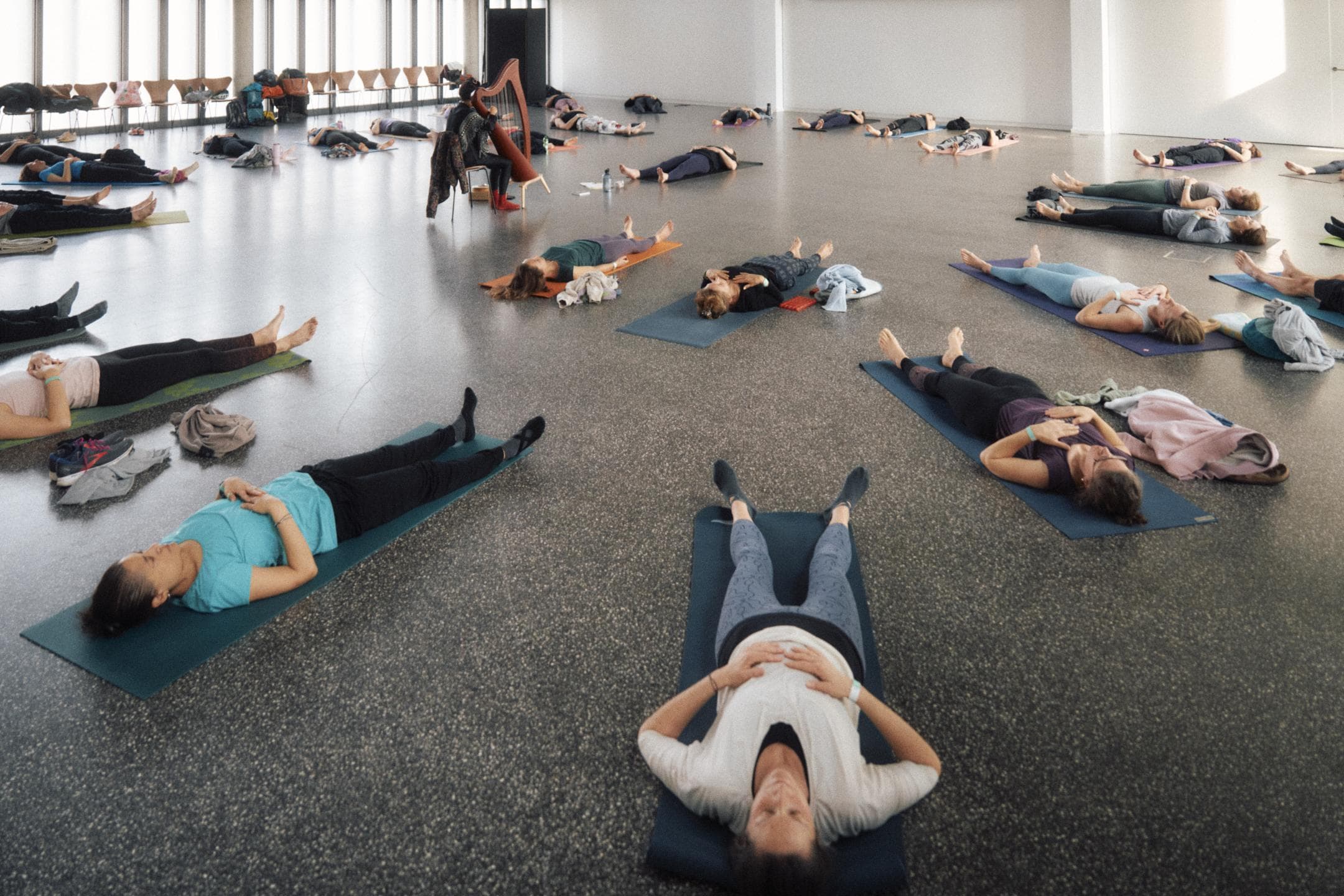 A person in a calm yoga posture, evoking the Bergson after-work yoga concert set to live music.