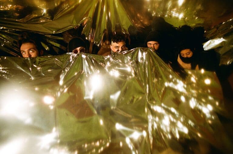 The band Prostitute photographed together on grainy gold-toned 35mm film.