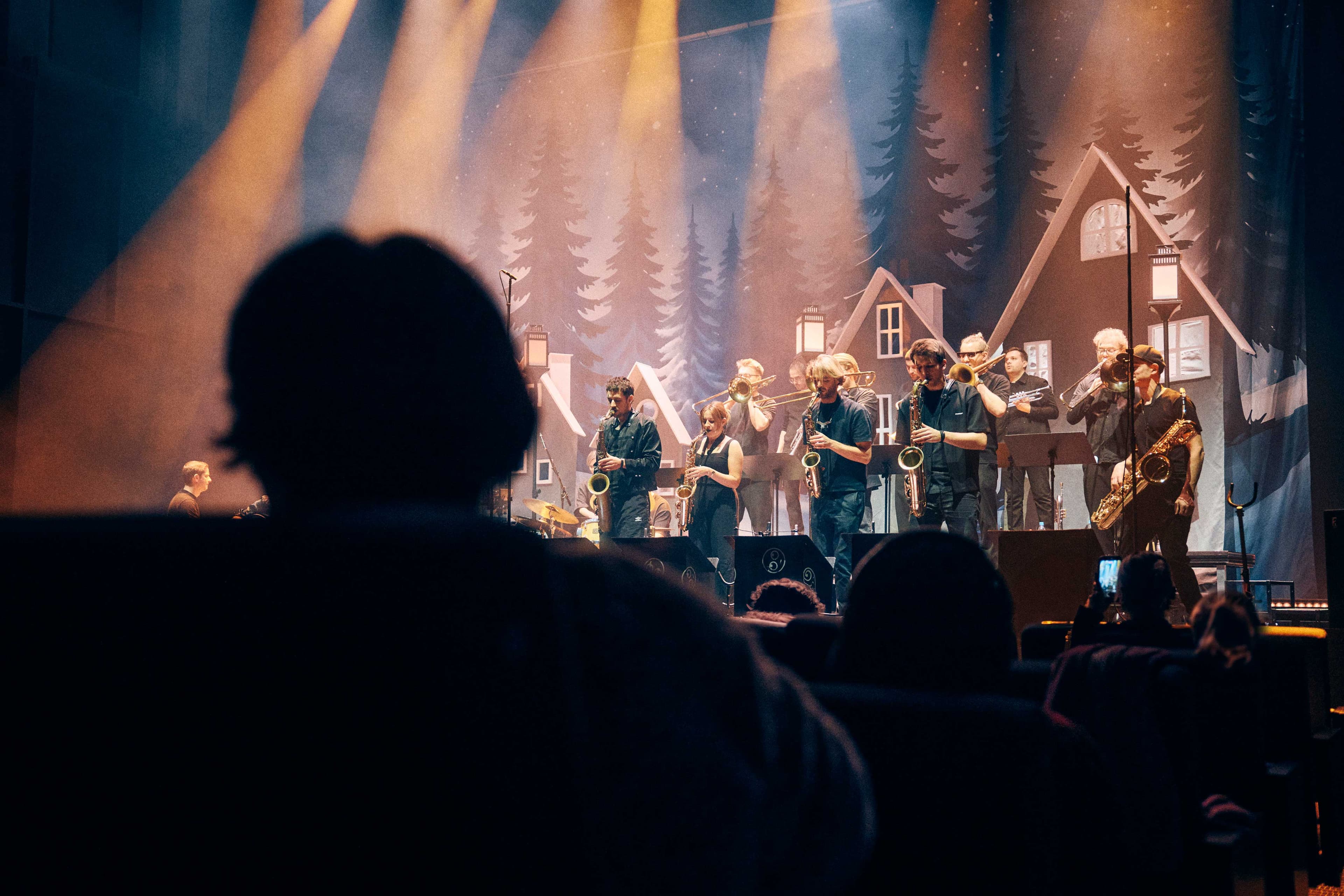 The Jazzrausch Bigband performing on stage with brass and rhythm sections under warm lighting.