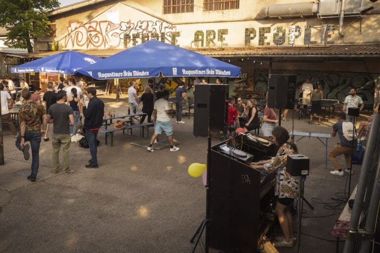 People playing table tennis next to DJ decks at TurnTableTennis.