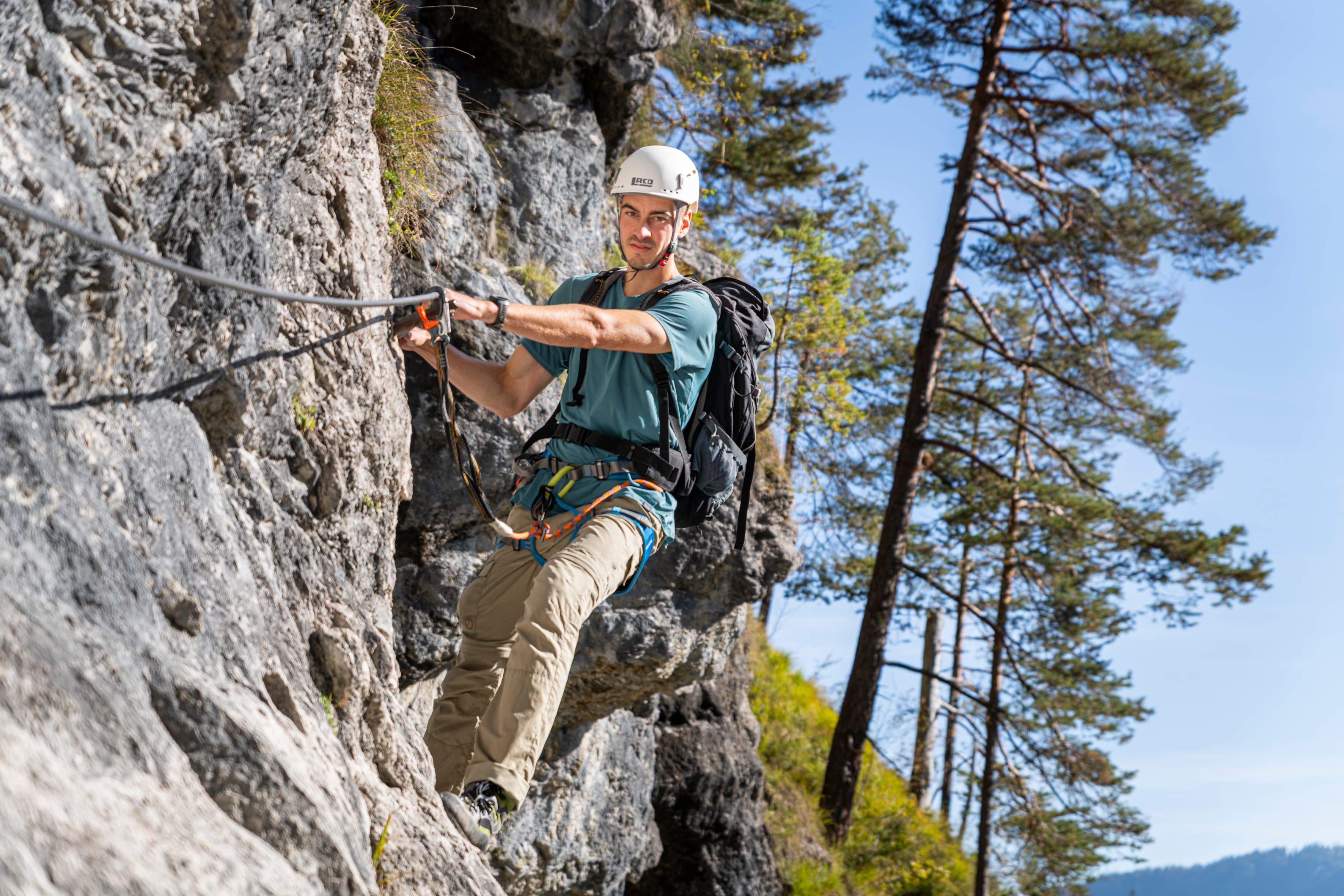 A helmeted climber clipped to the Hausbachfall via ferrata near Reit im Winkl.