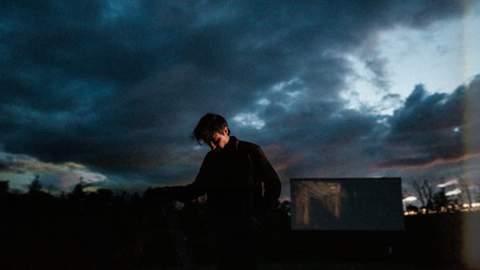 The Bones of J.R. Jones performer photographed outdoors, guitar in hand.