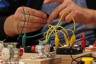 Hände bearbeiten Kabel im Schaltkreis