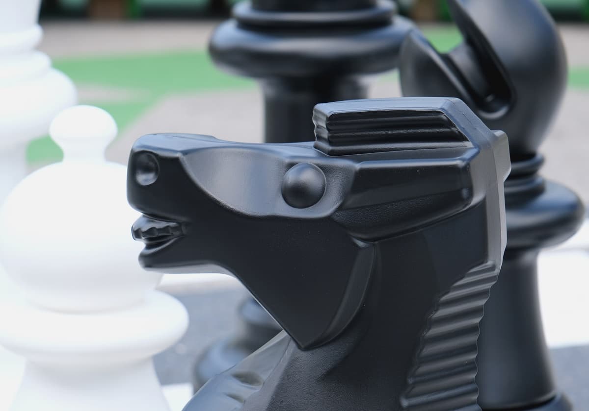 Close-up of a black chess knight on a board