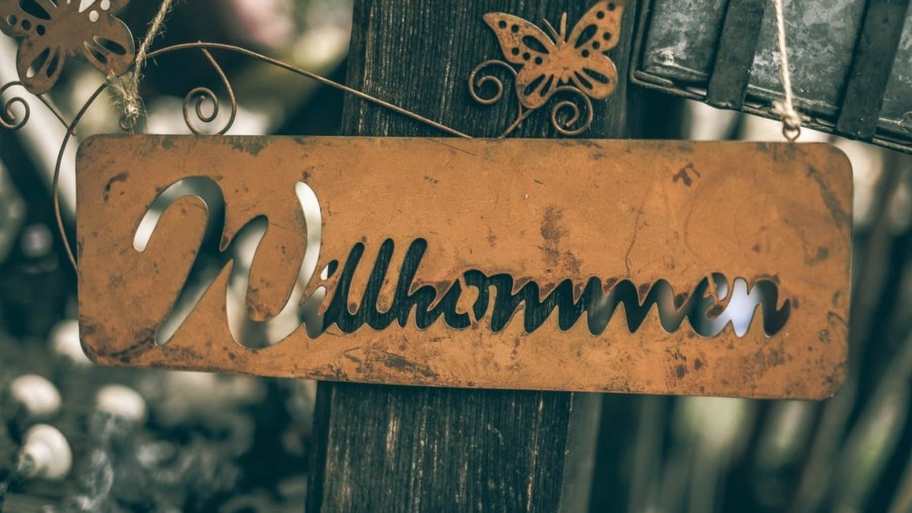 A garden fence with a welcome sign