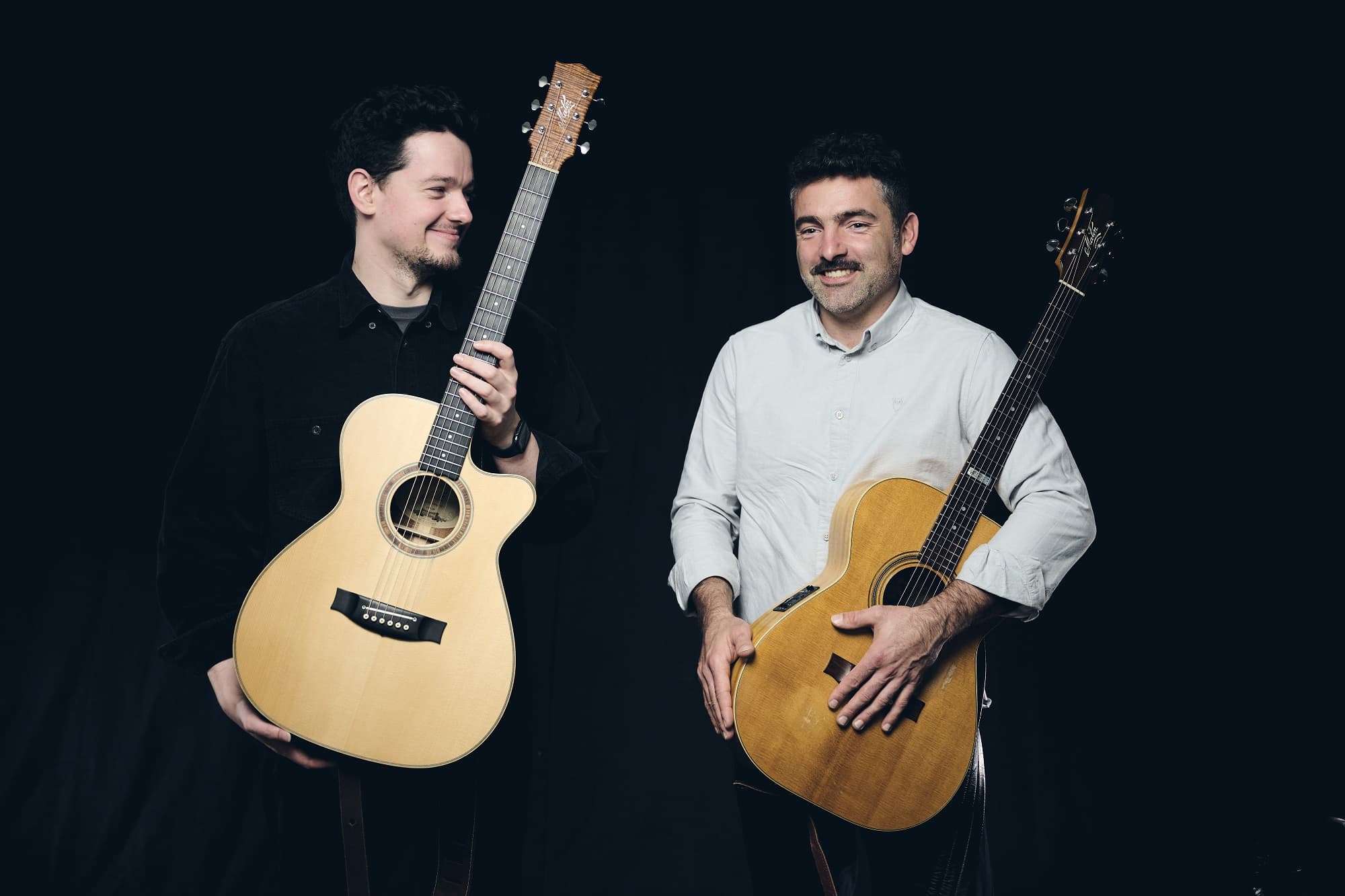Guitarists Jordan Brodie and Micha Kern with acoustic guitars