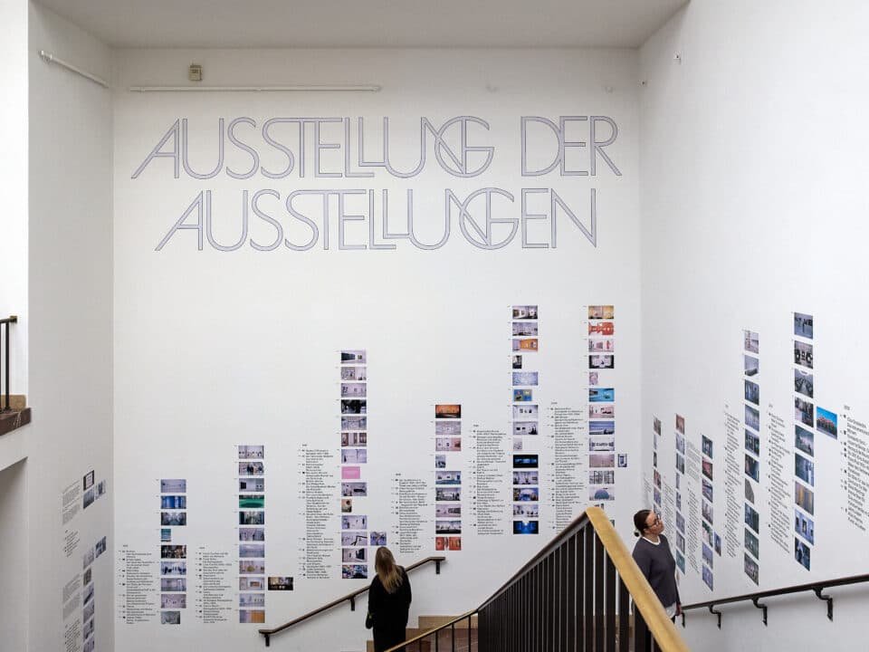 Stairwell display of the Ausstellung der Ausstellungen with framed exhibition documentation