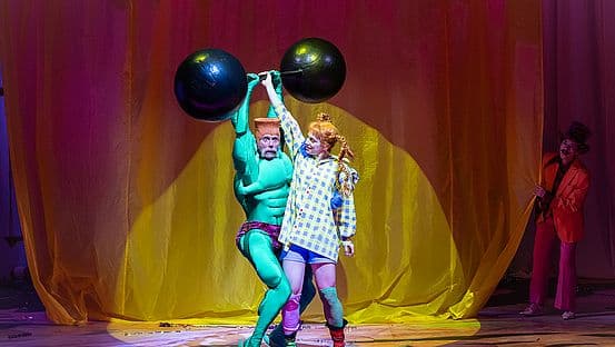 Scene from the Residenztheater staging of Pippi Langstrumpf, with the red-haired heroine in a colourful costume.